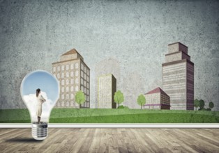 Businesswoman inside light bulb against city drawn concept
