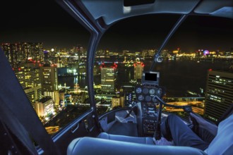 Helicopter flying over Tokyo cityscape, the Bay area with its bridges and Odaiba by night from
