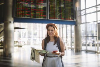 Theme travel and transportation. Beautiful young caucasian woman in dress and backpack standing