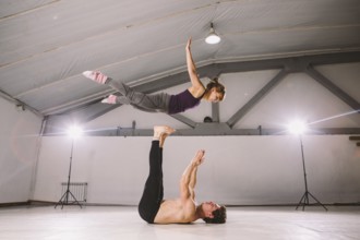 Young couple Couple practicing acro yoga in gym. Healthy lifestyle. Acroyoga. Couple yoga. Partner