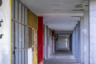 Abandoned row of shops with colourful doors and graffiti
