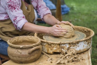 Hands of a woman making a clay pot on a potter's wheel in Boleslawiec, Poland, Europe