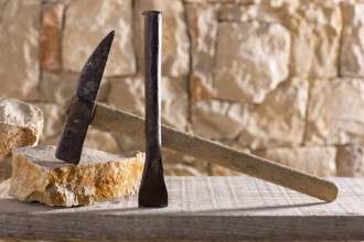 Hammer mason tools of stonecutter masonry work in a contruction stone wall