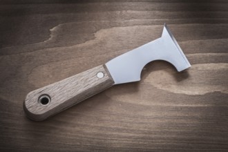 Metal putty knife on vintage wood board horizontal image