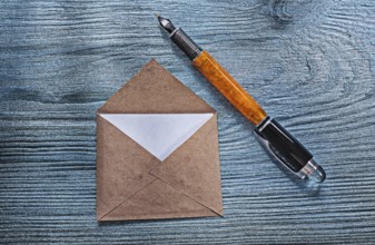 Vintage opened envelope with message fountain pen on wooden board