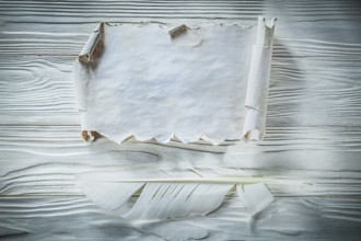 Vintage crumpled paper roll feather on wooden board
