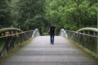 Man walking over a pedestrian bridge at Peterbos, Anderlecht, Brussels Capital Region, Belgium.