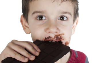 Smiling kid eating chocolate. Smeared stained with chocolate lips. White isolated