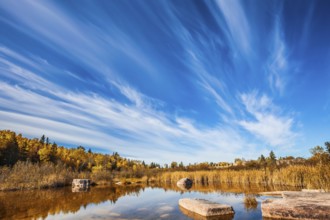 Wonderful autumn day. Indian summer in Manitoba, Canada. Cirrus clouds are reflected in the