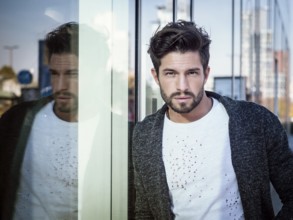 One handsome young man in urban setting in European city, standing