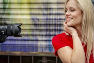 A beautiful blonde woman poses joyfully for the camera, showcasing her stylish spring clothing.