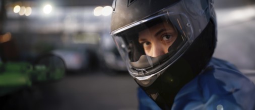 Close-up of a person wearing a helmet, intensely focused and prepared for riding at night