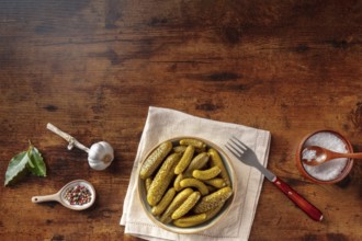 Pickled cucumbers with salt, pepper, garlic, and bay leaf. Fermented food. Homemade canned gherkins