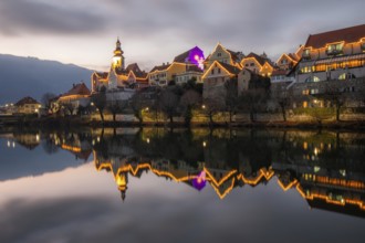 Christmas illuminated house facade of Frohnleiten reflected in the river Mur, Frohnleiten, Styria,