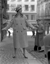 Fashionable in the 1950s. A young woman wears a typical 1950s coat. She poses in the outfit in a