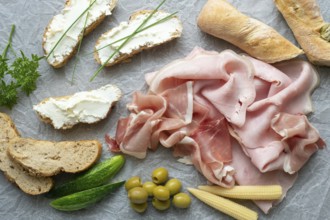 Cold appetizer. Cold cuts. Different snacks on a white crumpled paper, ham, bread, vegetables, from