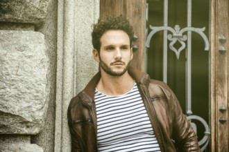 Attractive young man outdoor wearing leather jacket, in European city, Turin in Italy