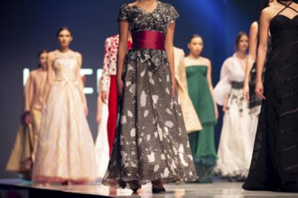 Female models walk the runway in beautiful colorful dresses during a Fashion Show. Fashion catwalk