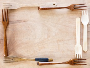 Wooden kitchenware frame on a wooden background from above. Studio shot. Kitchen utensil