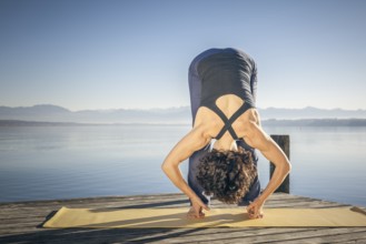 A pretty woman doing yoga at the lake