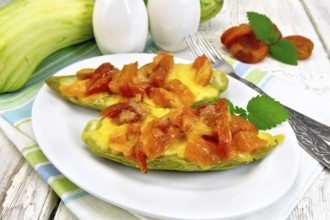Young zucchini baked in a flavored sauce with dried apricot, cream and cheese in a bowl on a