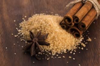 Cinnamon sticks with pure cane brown sugar on wood background