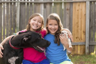 Twin sisters puppy pet dog and great dane playing together