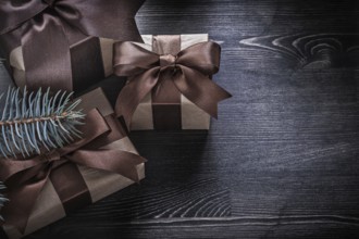 Fir branch Christmas gift boxes on wooden board holiday concept