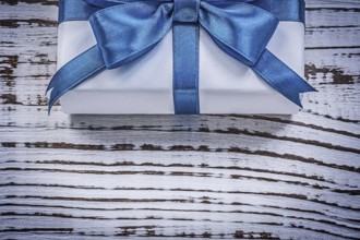 Wrapped gift box on vintage wooden board holidays concept