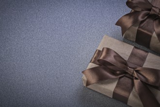Giftboxes in brown wrapping paper on grey background celebrations concept