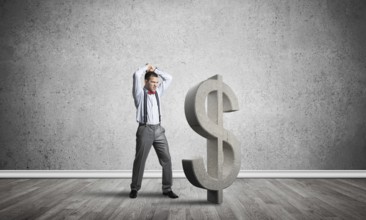 Young furious businessman going to crash with hands stone dollar symbol