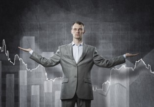 Businessman with spread arms and growing graphs on chalkboard