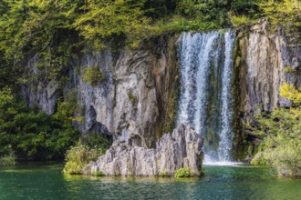 Charming little waterfall with a vertical ledge. Cascading Plitvice lakes in Croatia on a cloudy