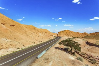 Straight as an arrow the road crosses the hills. Dry waterless hills of yelloy and beige clay.