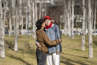 Young gay couple about to kiss in a park