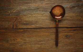 Aged cooper ladle vintage on wooden table retro