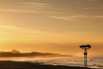View of the Bamburgh castle in a spectacular sunset from the Seahouses, Great Britain