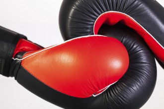 Red and black boxing gloves on a glass table isolated on white background