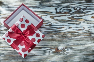 Red packed gift box on vintage wooden board