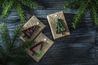 Handmade present boxes fir tree branch on wooden board