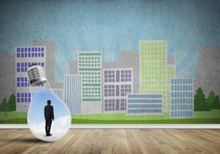 Businessman inside light bulb against city drawn concept