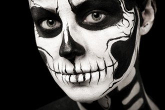 Isolated on black, closeup picture, beautiful young brunette caucasian woman with scull body art,