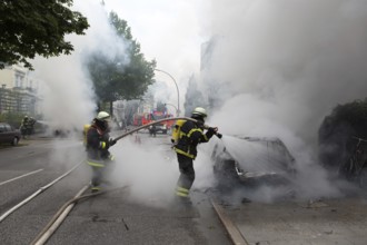 Fire brigade extinguishes burning cars on the Elbchaussee in Hamburg after the riots at the G20