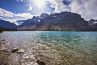 The cold waters of the lake surrounded by scenic Canadian Rocky Mountains. Azure Bow Lake in Banff