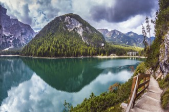 Magnificent Alpine lake Lago di Braies. Walking trail around the lake is fenced with wooden