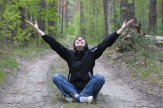 A man in the forest. A middle-aged woman sits on a forest path