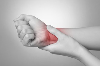 A young woman holding her painful wrist