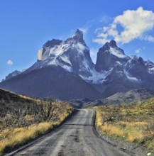 Dreamland Patagonia. Snow-covered cliffs of Los Cuernos, to them is a road of black gravel