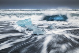 Ice floes on the black sea sand and the coast Jokulsarlon