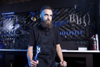 Portrait of small business owner of young man with beard. Guy bicycle mechanic workshop worker